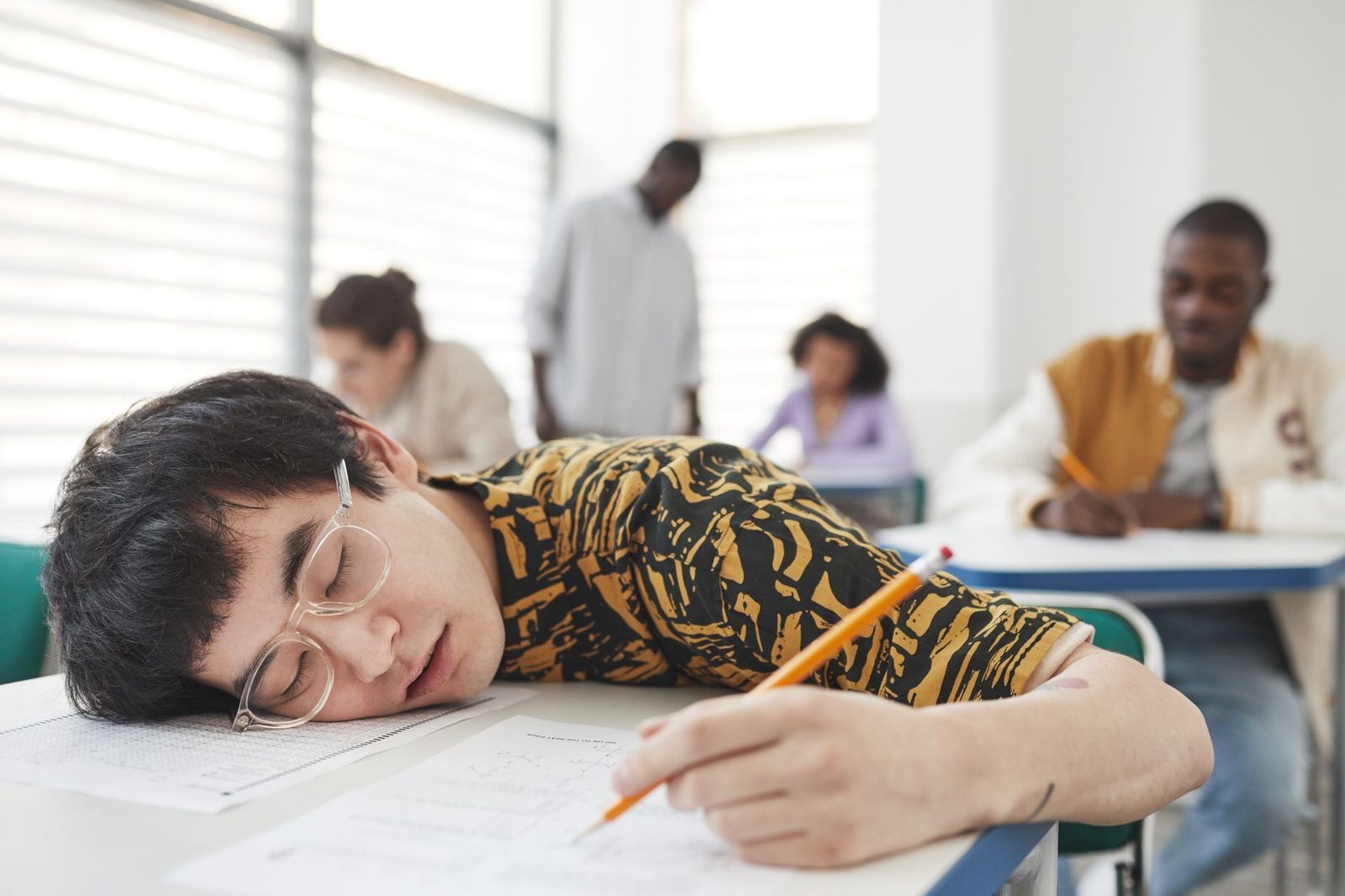 Student looking stressed while reviewing college application paperwork