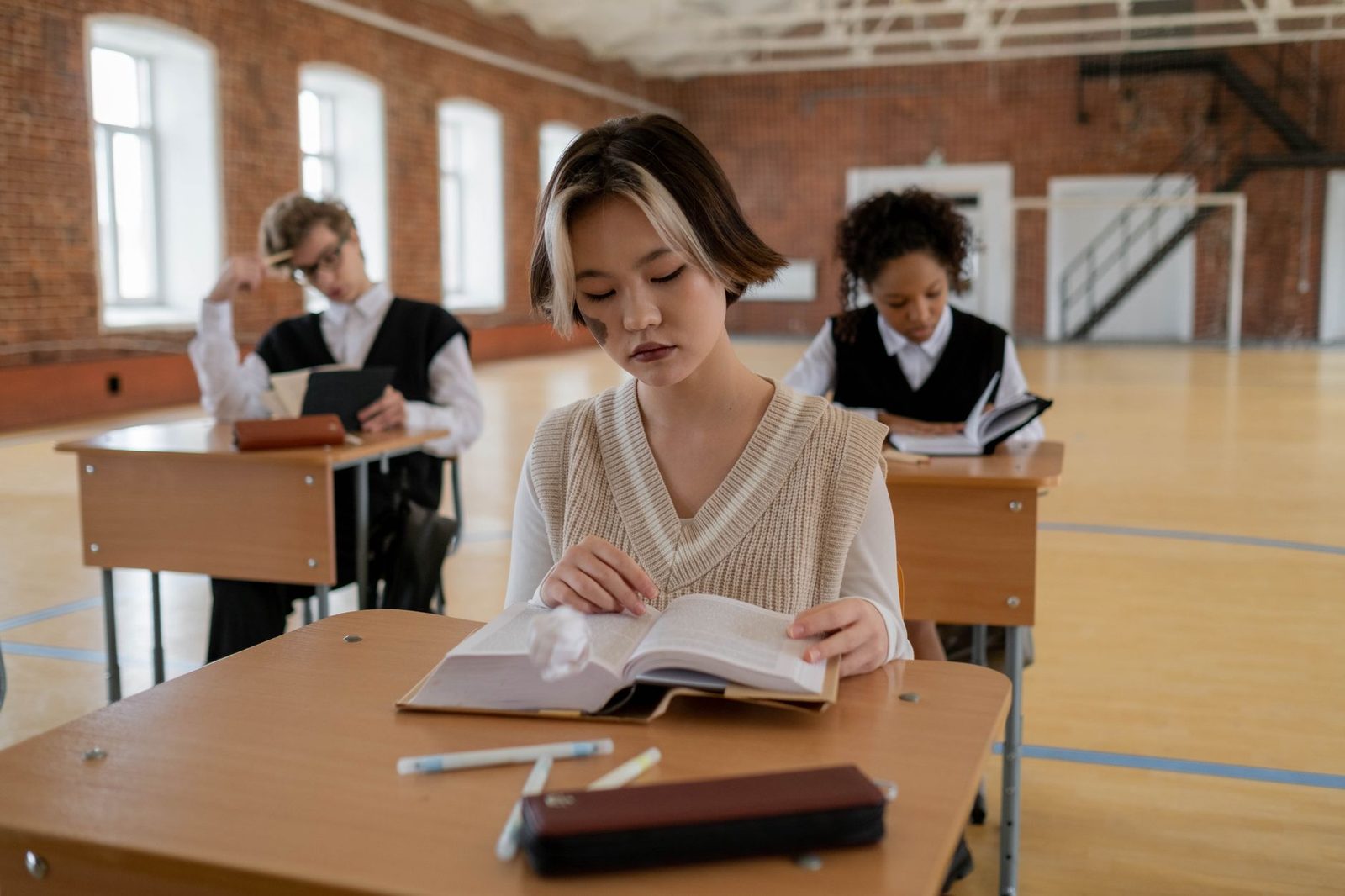 Student studying at a desk with notes and laptop