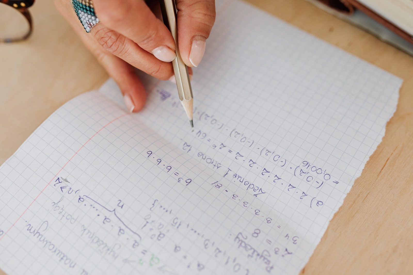Student working through math practice problems with notes